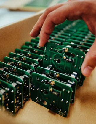 Placas eletrônicas sendo embaladas em uma caixa de papelão para envio ao cliente